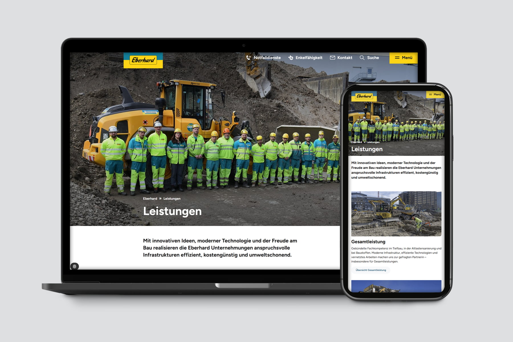 Eberhard-Team vor Baumaschinen auf Laptop und Smartphone-Bildschirm
