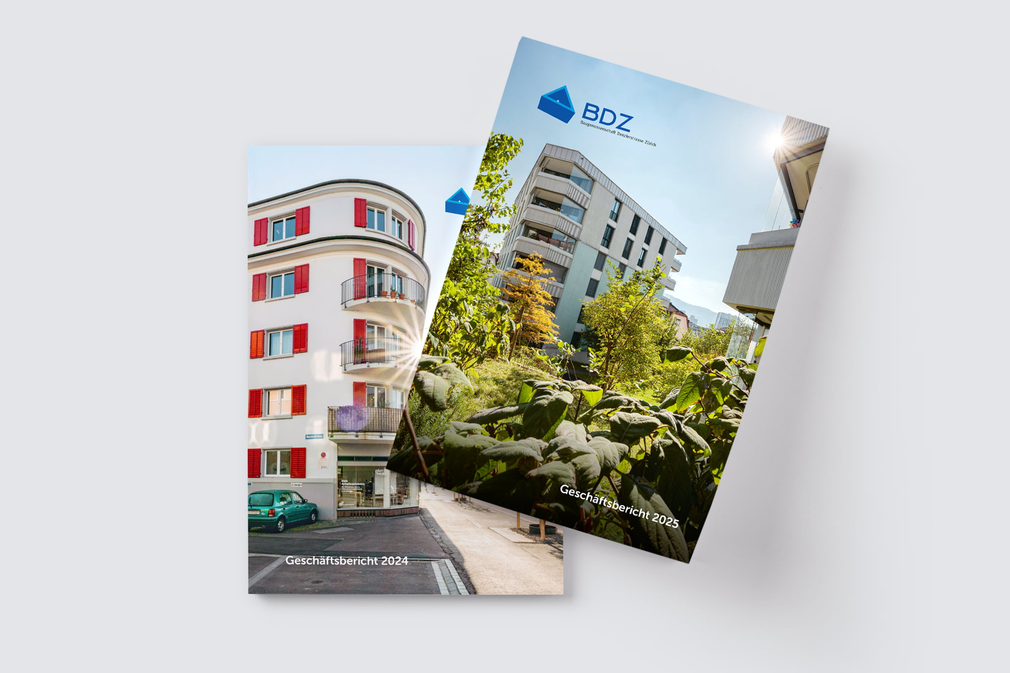Zwei Broschüren mit Gebäudefotos und dem Text Geschäftsbericht 2024 und Geschäftsbericht 2025.